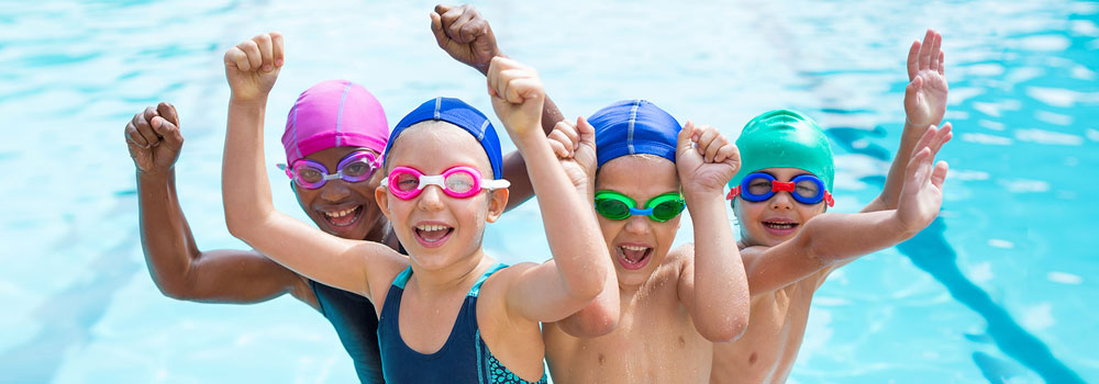Four kids having fun in a pool smiling